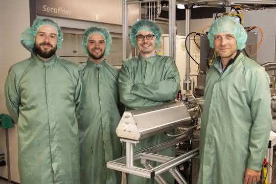 Vier Wissenschaftler in grünen Kitteln und mit grünen Haarnetzen