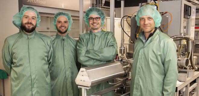 Vier Wissenschaftler in grünen Kitteln und mit grünen Haarnetzen