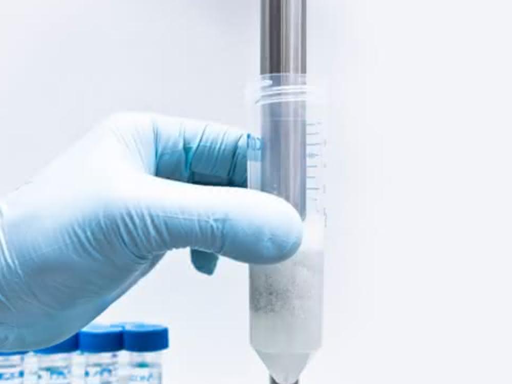 Hand hält Behälter mit Probe beim Dispergiervorgang