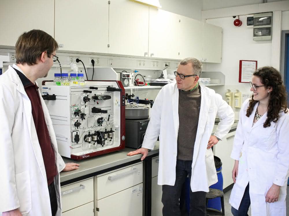 Dr. Frank Mickoleit, Prof. Dr. Dirk Schüler und Clarissa Lanzloth B.Sc. an einem Gerät zur Analyse, Isolation und Reinigung von Proteinen Dr. Frank Mickoleit, Prof. Dr. Dirk Schüler und Clarissa Lanzloth B.Sc. im Labor