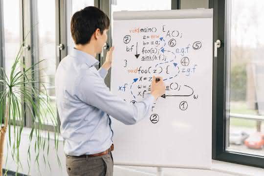 Junger Mann vor Flip Chart mit Formeln