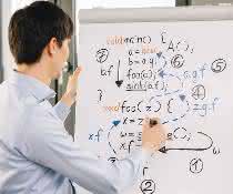 Junger Mann vor Flip Chart mit Formeln