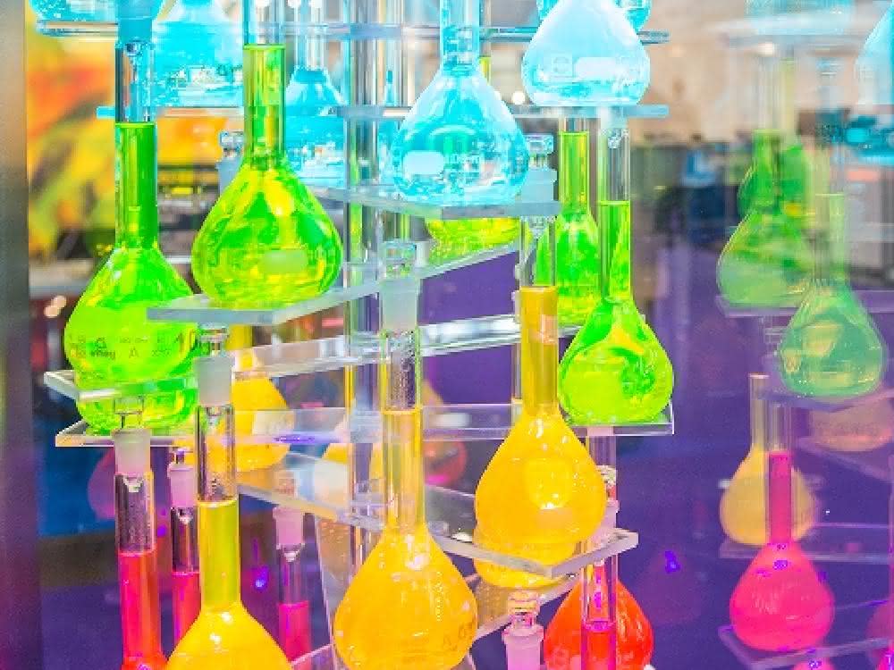 Viele Glaskolben mit Flüssigkeiten in verschiedenen Farben gefüllt (Teil einer Ausstellung)