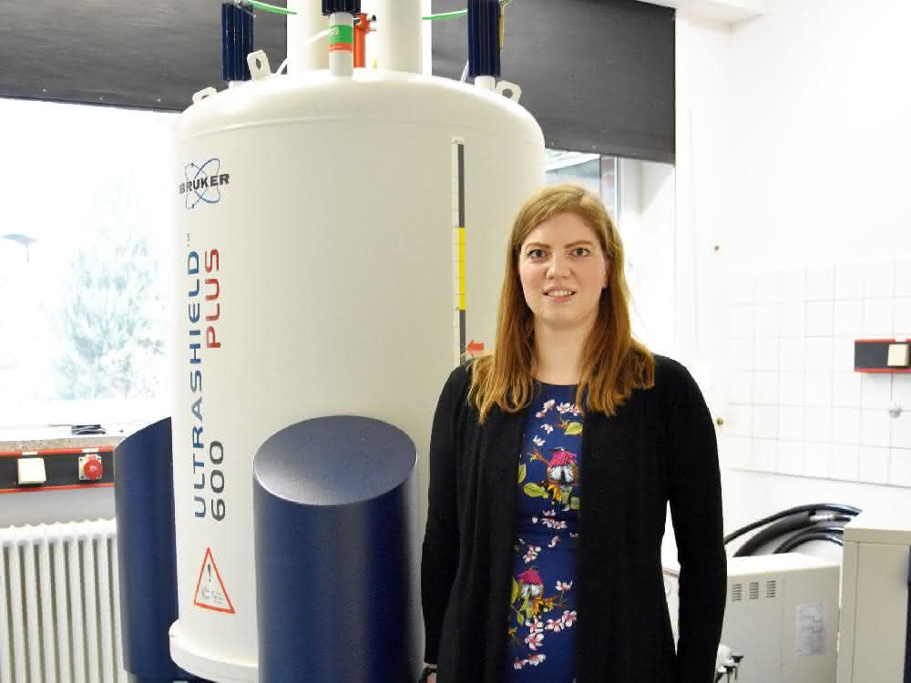 Juniorprofessorin Anna McConnell im Labor. Mit den Methoden des Kieler Teams können herkömmliche Spektrometer wie das am Otto-Diels-Institut für Organische Chemie so angepasst werden, dass sie auch paramagnetische Verbindungen untersuchen können. © Julia Siekmann, CAU Anna McConnell im Labor neben einem Spektrometer.