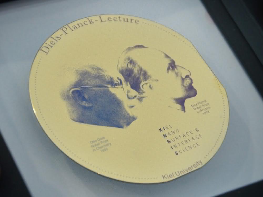 Die Diels-Planck-Medaille, die Prof. Grätzel erhalten hat, wurde aus einer Siliziumscheibe im Reinraum des Kieler Nanolabors hergestellt. Sie zeigt die Nobelpreisträger Max Planck und Otto Diels, die Begründer der Kieler Nanowissenschaften. Diels-Planck-Medaille. Auf ihr sind die Nobelpreisträger Max Planck und Otto Diels zu sehen.