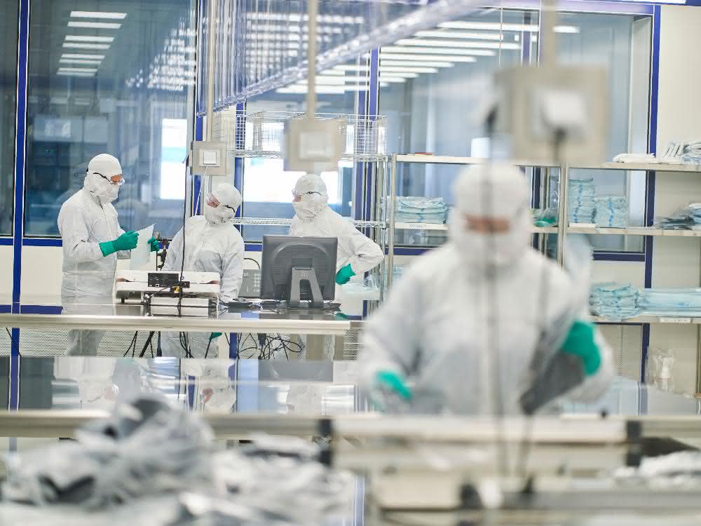 Zertifizierte Aufbereitungsprozesse: Keimfreie Berufskleidung Reinraum mit Personen