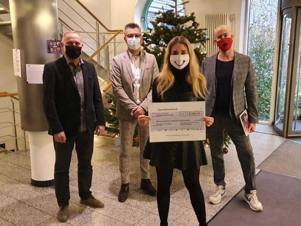Eva-Maria Büttner zeigt den Scheck. Dahinter im Bild: Dirk Waasen, Peter Eberhard und Matthäus Hose.