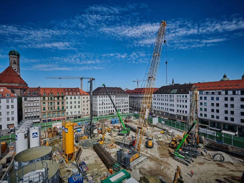 Grüne Krane in weiß-blauer Großstadt