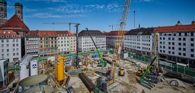 Grüne Krane in weiß-blauer Großstadt
