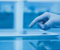 Hand (mit Laborhandschuh) bedient Tablet
