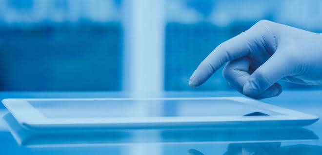 Hand (mit Laborhandschuh) bedient Tablet