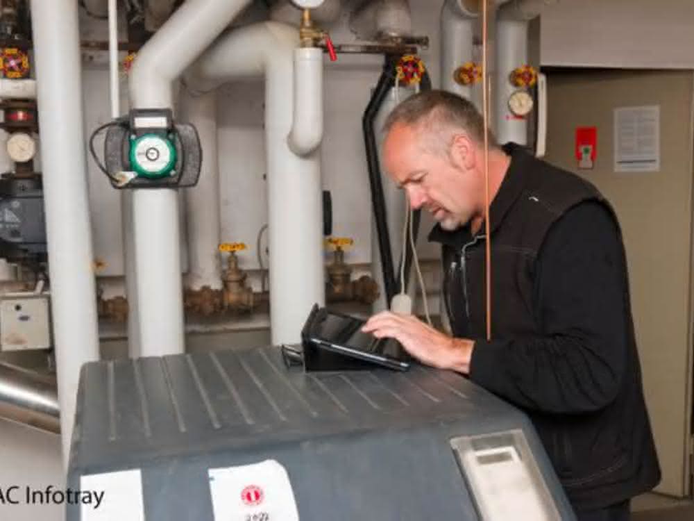 Person in Technikbereich zur Wasserversorgung schaut auf ein Gerät