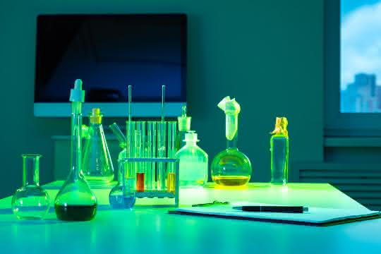 Glaskolben, Reagenzgläser auf einem Tisch und Bildschirm