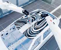 Robot arms spray car roof