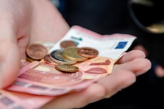 Euro-Scheine und -Münzen in der Hand