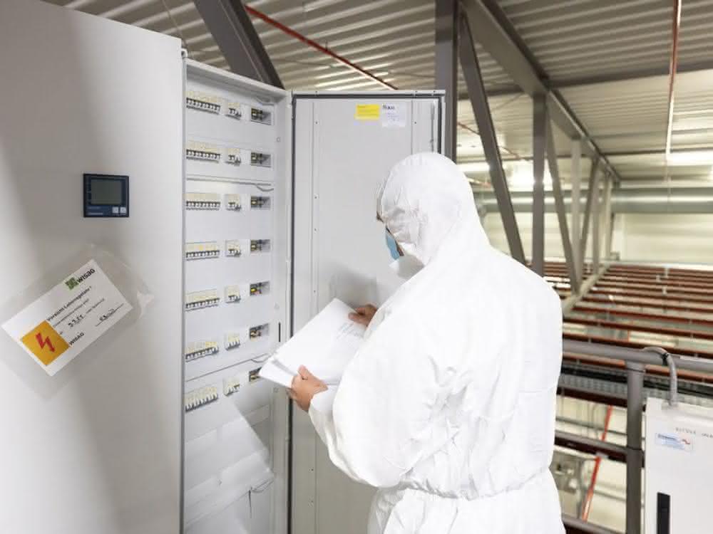 Unterverteilung Person in Reinraumkleidung am Verteilerschrank