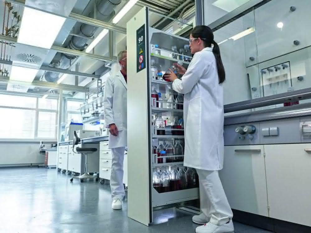 Vorbeugende Maßnahmen schützen: Gefahrstoffe sicher handhaben und lagern Labormitarbeitende an einem Gefahrstoffschrank im Labor
