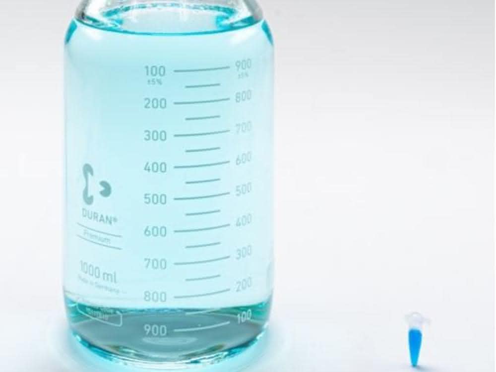 Bakterien in Umwelt- und Industriewässern bestimmen: Aufkonzentrieren für die Analytik Große Probenflasche und ein kleines Probengefäß mit Flüssigkeit