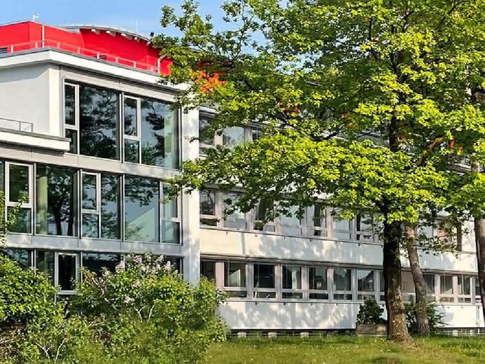 The new building is harmoniously embedded in old trees right next to the Wilhelmberg forest