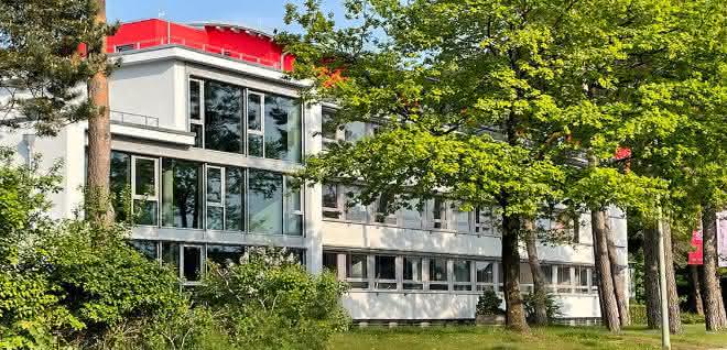 Team celebrates 40th anniversary: Four decades of digitization The new building is harmoniously embedded in old trees right next to the Wilhelmberg forest