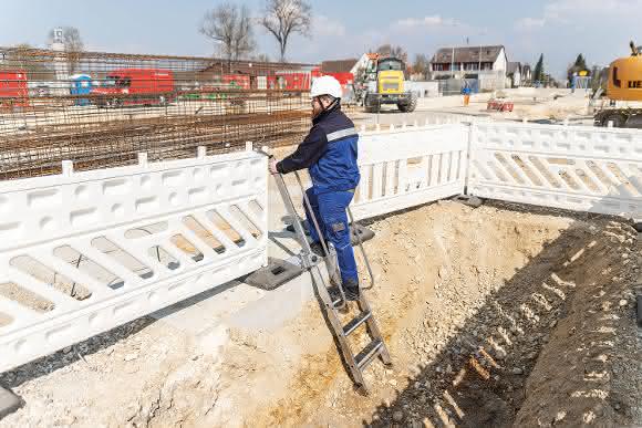 Die extra breite, höhenverstellbare Plattform lässt sich am Baugrubenrand arretieren, beidseitige Handläufe bieten einen sicheren Halt.